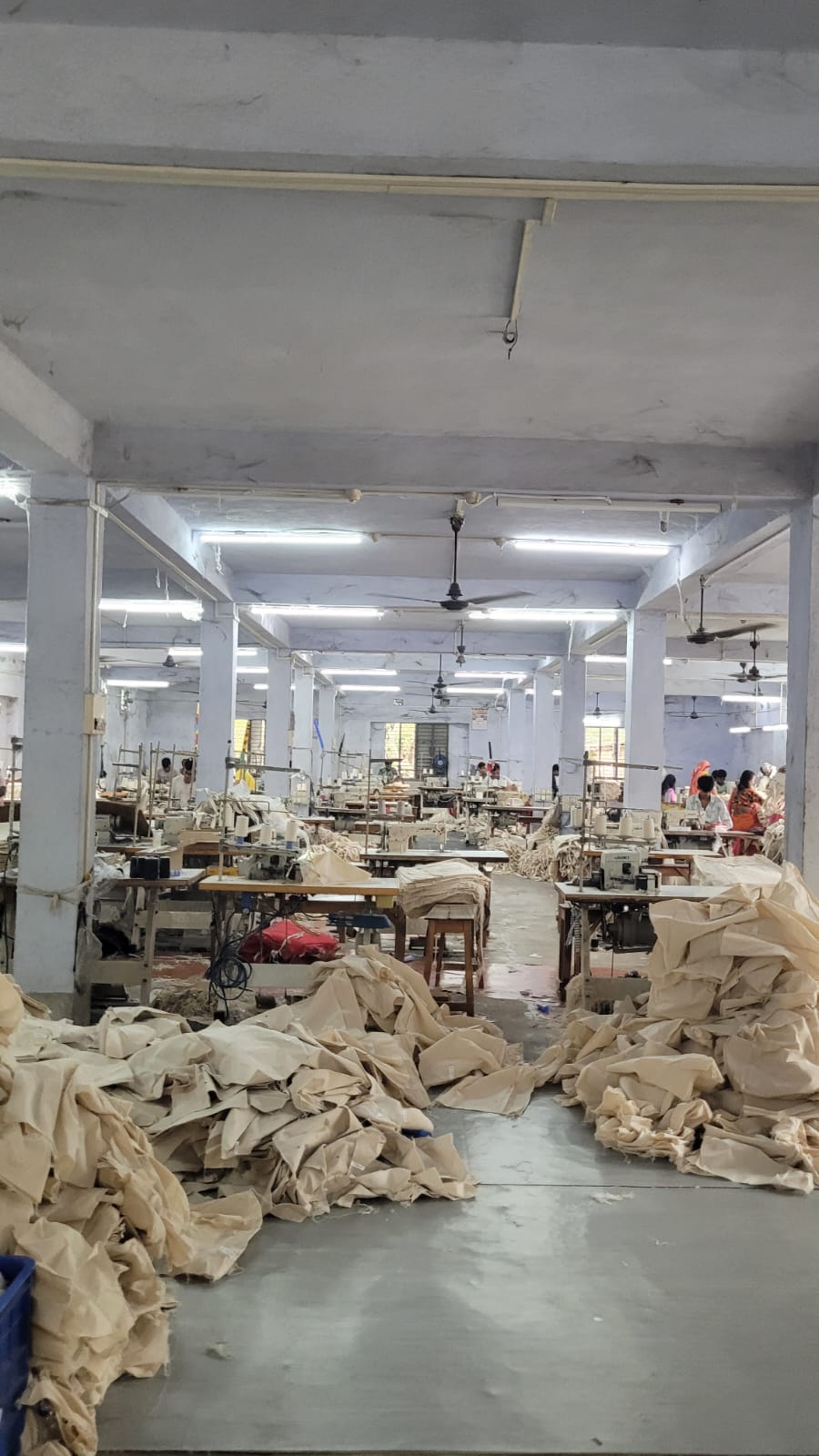 Artisans cutting raw jute fabric for bag production