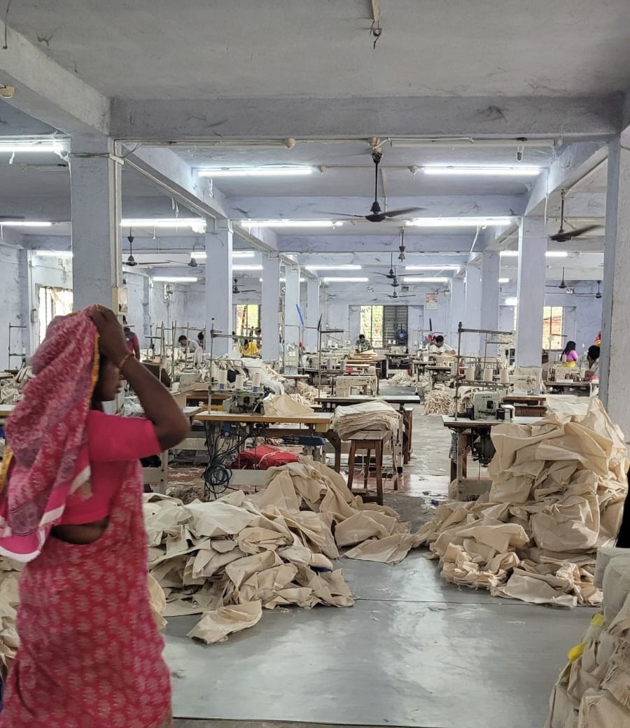 Artisans cutting raw jute fabric for bag production